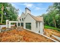 White brick home with modern design, wood shingle roof, and pool under construction in wooded lot at 2983 Habersham Nw Ct, Atlanta, GA 30305