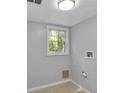 Bright laundry room with window, neutral paint, and tile flooring at 4373 Sun Valley Blvd, Atlanta, GA 30344