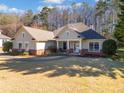 Inviting home showcases a well-maintained lawn, brick foundation, and covered front porch, a true delight at 153 Newcastle Walk, Woodstock, GA 30188