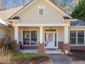 The welcoming front porch features brick columns, detailed trim, and a glass-paneled door, inviting guests inside at 153 Newcastle Walk, Woodstock, GA 30188