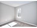 Cozy bedroom features neutral carpet, fresh light gray paint, and natural light from the window at 4751 Lorient Ct, Snellville, GA 30039