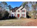 Charming two-story home with red shutters, complemented by a well-maintained lawn and mature trees at 4751 Lorient Ct, Snellville, GA 30039