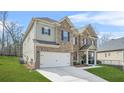 Side view of a two-story brick home with an attached garage and well maintained lawn on a sunny day at 4826 Ralin Ct, Atlanta, GA 30331