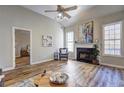 Spacious living room featuring a fireplace, hardwood floors, and a view into the adjacent bedroom at 1620 Rising Mist Ln, Cumming, GA 30041