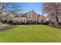 Beautifully landscaped front yard featuring lush green lawn and mature trees around this gorgeous home at 700 Clubside Dr, Roswell, GA 30076