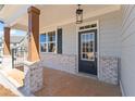 Front entryway featuring a covered porch with brick columns and a glass paneled door at 162 Spaulding Ln, Woodstock, GA 30188