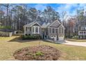 Well-maintained home with gray siding, a two-car garage, and landscaping, set in a wooded area at 3031 Clove Tree Ln, Woodstock, GA 30189