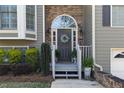 Close-up of the front door, featuring a wreath, stone accents, and manicured bushes at 3031 Clove Tree Ln, Woodstock, GA 30189