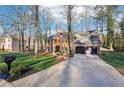 Brick home with a driveway and two-car garage, surrounded by mature trees and a well-groomed lawn at 4506 Reva Ne Way, Marietta, GA 30066