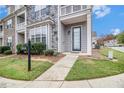 Close-up of a townhome with a stone accent, walkway and manicured lawn at 7808 Rutgers Cir, Fairburn, GA 30213