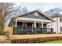 Beautiful home featuring a cozy front porch, with a stone retaining wall and freshly installed fencing at 973 Parsons Sw St, Atlanta, GA 30314