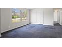 This bedroom offers natural light from two windows and ample space, complete with neutral walls and carpet flooring at 1833 Lost Mountain Rd, Powder Springs, GA 30127