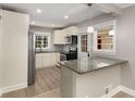 Cozy kitchen with granite countertops, stainless steel appliances, white cabinets, and modern pendant lighting at 2462 Macon Sw Dr, Atlanta, GA 30315