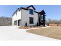 Side view of a modern two-story home with a spacious driveway and manicured lawn at 3066 Reserve Ct Sw, Conyers, GA 30094