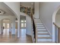 Welcoming foyer with light hardwood floors, an elegant staircase, and arched doorways at 3066 Reserve Ct Sw, Conyers, GA 30094