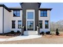 Stunning front entrance with stairs leading up to a modern, black-framed glass door at 3066 Reserve Ct Sw, Conyers, GA 30094