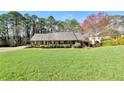 Spacious front yard featuring a well-manicured lawn of a one-story home with mature landscaping at 3075 Wood Valley Dr, Mcdonough, GA 30253