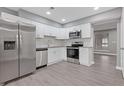 Modern kitchen with stainless steel appliances, white cabinets, and gray flooring at 4715 Old Highgate Entry, Stone Mountain, GA 30083