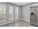 Bright kitchen area featuring stainless steel refrigerator and ample natural light from multiple windows at 4715 Old Highgate Entry, Stone Mountain, GA 30083