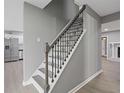 Elegant staircase with dark metal railing and gray and white paint, leading to the upper level at 4715 Old Highgate Entry, Stone Mountain, GA 30083