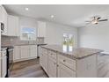 Bright kitchen with stainless steel appliances, granite countertops, kitchen island, and white cabinetry at 839 Pensive Run, Dacula, GA 30019