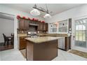 Kitchen featuring granite countertops, stainless steel appliances, ample cabinetry, tiled floors, and an island at 900 Cherringham Ct, Alpharetta, GA 30005