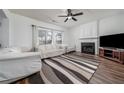 Bright living room with a fireplace, white sofas, neutral rug, ceiling fan, and hardwood flooring at 900 Cherringham Ct, Alpharetta, GA 30005