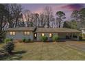 Charming single-story home with stone accents and a covered carport at dusk at 803 Denise Sw Ct, Stone Mountain, GA 30087