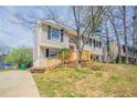 Charming two-story home with tan siding, black shutters, a red front door, and a wooden porch and rails at 5415 Tracey Dr, Stone Mountain, GA 30088