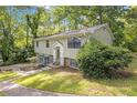 Charming split-level home surrounded by mature trees and greenery, with a well-manicured lawn at 4690 Big Valley Ct, Stone Mountain, GA 30083
