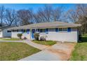 A charming single-story home with blue shutters, blue front door, and mature trees at 1393 Vesta Ave, Atlanta, GA 30344