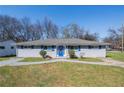 Charming single-story home with blue shutters, a blue door, and mature trees at 1393 Vesta Ave, Atlanta, GA 30344