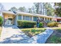 Exterior view of home featuring an attached carport, updated landscaping, and covered front entrance at 264 Silver Springs Sw Cir, Atlanta, GA 30310