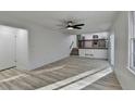 Open-concept living area with wood flooring, a ceiling fan, and access to the kitchen at 2887 Hickory Ln, Snellville, GA 30078