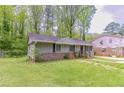 Cozy one-story home with mature trees in the background and a well-manicured lawn at 4089 Lindsey Dr, Decatur, GA 30035
