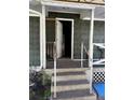 Exterior porch with concrete steps, peeling paint, and doorway into the home at 406 Dallas Hwy, Villa Rica, GA 30180