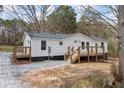 Charming single-story home with a freshly painted exterior, a wooden deck, and a gravel driveway at 75 Woodfield Rd, Covington, GA 30014
