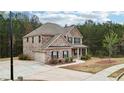 Two-story brick home with a large driveway, attached garage, and well-maintained landscaping at 104 Amelia Way, Ellenwood, GA 30294