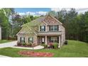 Charming brick home with lush green lawn, tree accents and inviting front porch with lovely curb appeal at 104 Amelia Way, Ellenwood, GA 30294