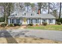 Charming single Gathering home featuring a yellow front door, blue shutters, and well maintained lawn at 1495 Longwood Sw Dr, Marietta, GA 30008