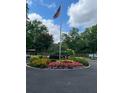 Beautifully landscaped roundabout with vibrant flowers and an American flag, creating an attractive welcome at 1800 Clairmont Lk # A719, Decatur, GA 30033