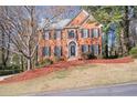 Traditional brick home showcasing a symmetrical design, black shutters, and a manicured front lawn at 2542 Ashridge Ct, Lawrenceville, GA 30043