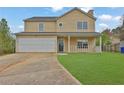 Inviting two-story home with a well-manicured lawn, front porch, and attached two-car garage at 864 Oakhill Ct, Stone Mountain, GA 30088