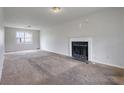 Spacious living room featuring a fireplace, large window, and neutral carpet flooring at 864 Oakhill Ct, Stone Mountain, GA 30088