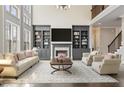 Bright living room boasts soaring ceilings, custom built-ins, a fireplace, and plush furniture at 2315 Monet Dr, Cumming, GA 30041
