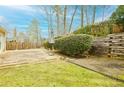 Spacious backyard with a stone patio, lush grass, and wooden fence; perfect for entertaining and relaxing at 2698 Glenrose Hl, Atlanta, GA 30341