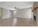 Neutral-toned living room features a ceiling fan, wood-look vinyl floors and a stone fireplace at 585 Lake Dr, Snellville, GA 30039