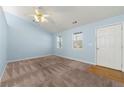 Bright living room with neutral walls, carpet flooring, ceiling fan, and plenty of natural light at 135 Tanyard Ct, Newborn, GA 30056