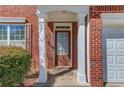 Close up of the covered front entryway, featuring a wooden door with decorative glass and white pillars at 1554 Park Grove Dr, Lawrenceville, GA 30046