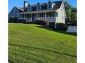 Traditional two-story home featuring a covered front porch and lush green lawn at 2467 Sky Valley Dr, Dacula, GA 30019